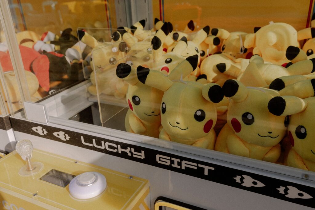 Pikachu plush toys inside an arcade claw machine labeled 'Lucky Gift'.